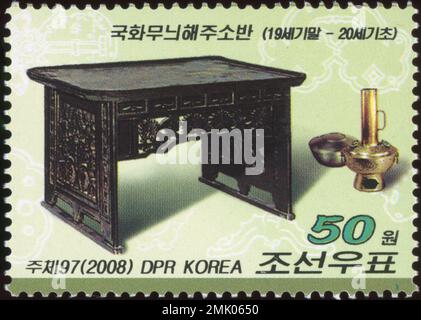 Francobollo nordcoreano del 2008 con un tradizionale tavolo Haeju Soban con motivi al crisantemo e un vaso in ottone. Foto Stock