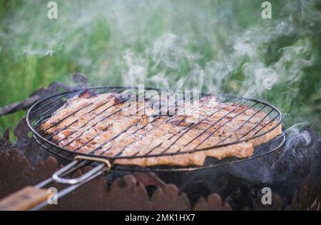 la carne viene friggita sulla griglia rotonda Foto Stock