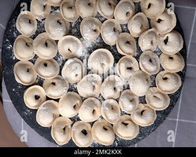 Foto in studio di gnocchi russi fatti a mano (Pelmeni): Arte culinaria tradizionale in un ambiente pulito e minimale. Foto Stock