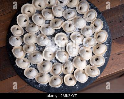 Foto in studio di gnocchi russi fatti a mano (Pelmeni): Arte culinaria tradizionale in un ambiente pulito e minimale. Foto Stock