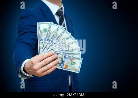 Uomo d'affari in possesso di denaro contante dollari nelle mani di passare al cliente Foto Stock