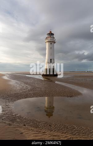 New Brighton, Regno Unito: Faro di Perch Rock riflesso nelle piscine d'acqua con la bassa marea. Un simbolo iconico sulla penisola di Wirral. Foto Stock