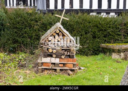 Bug insetto hotel nel terreno della chiesa con croce, lenham, kent, regno unito Foto Stock