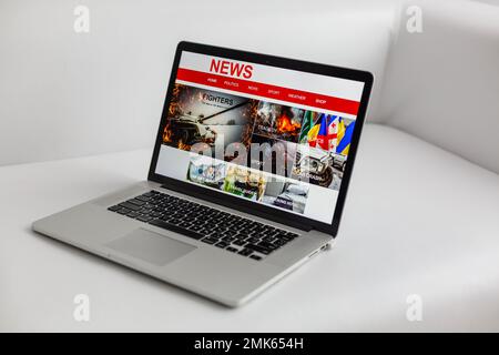 Immagine ritagliata di imprenditore per leggere le notizie sul portatile in ufficio Foto Stock