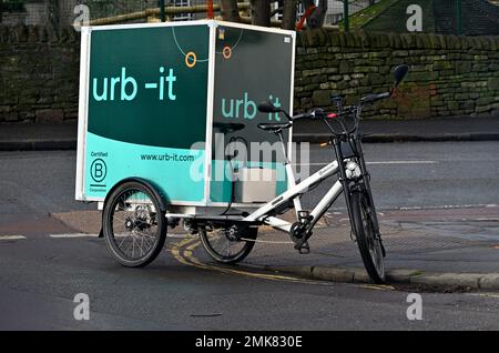 Bici da carico utilizzata per la consegna di pacchi con corriere ciclistico urb-IT parcheggiato illegalmente su due linee gialle direttamente all'angolo e bloccando pedoni Foto Stock