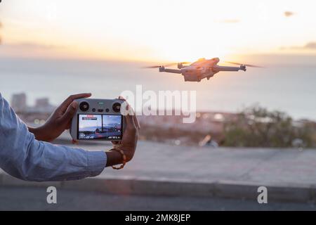 Tenerife, Spagna, 27th gennaio 2023: Un pilota controlla un drone DJI mini 3 Pro e mostra la schermata del controller Foto Stock