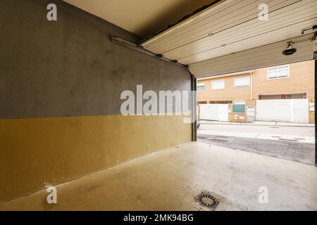 Garage vuoto di una casa indipendente con cancello scorrevole Foto Stock