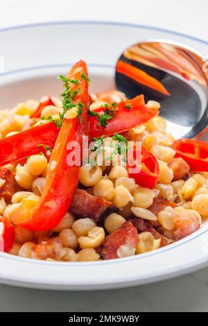 miscela di piselli gialli e pancetta servita con pepe rosso e peperoncino Foto Stock