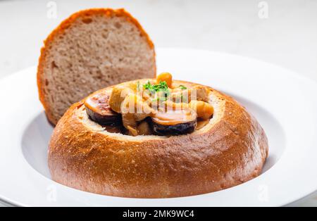 stufato con carne di maiale, ceci e sausge in pane Foto Stock