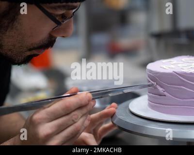 torta smerigliata di 20 anni decorata con una frase crema fatta a mano, perle, spolverate da designer panettiere Foto Stock