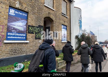 Tifosi di calcio in arrivo per una partita allo stadio Roots Hall del campo di calcio Southend Utd, Southend on Sea, Essex, Regno Unito. Pubblicità e graffiti Foto Stock