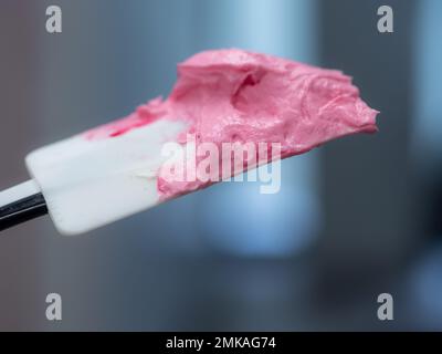 riempimento a glassa rosa per la decorazione di torte smerigliate in laboratorio di cucina Foto Stock