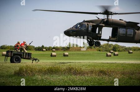 I soldati dell'esercito degli Stati Uniti si preparano ad agganciare un rimorchio ad un falco nero della Guardia nazionale dell'esercito dell'Iowa UH-60 durante un'esercitazione di caricamento della cinghia come parte di un corso del Pathfinder degli Stati Uniti a Camp Dodge in Johnston, Iowa, il 8 settembre 2022. Quasi 30 soldati si sono laureati al corso, che è stato insegnato da una squadra di addestramento mobile presso il Centro di addestramento della Guardia Nazionale dell'Armata a Fort Benning, Georgia. I Pathfinder dell'esercito sono addestrati a fornire aiuti alla navigazione e servizi di consulenza agli aeromobili militari nelle aree designate dai comandanti di unità supportati. Durante il corso Pathfinder, gli studenti vengono istruiti sull'orientamento dell'aeromobile Foto Stock