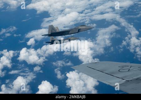 I comandanti in entrata e in uscita della 154th Wing Fly F-22 Raptors in formazione con un KC-135 Stratotanker 7 settembre 2022, vicino a Oahu, Hawaii. Il volo di addestramento di routine è servito come cerimonia di cambio di comando in volo come Brig. Il Gen. Dann S. Carlson ha ceduto il comando della più grande ala della Guardia Nazionale dell'aria al col. Phillip L. Mallory. Foto Stock