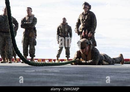 220909-N-XN177-2171 SOUTH CHINA SEA (SETTEMBRE 9, 2022) – U.S. Marine Corps Sgt. Kevin Gutierrez, di Los Angeles, assegnato alla 31st Marine Expeditionary Unit (MEU) funge da ancoraggio durante una rapida evoluzione di allenamento in corda a bordo di un carrier d'assalto anfibio USS Tripoli (LHA 7) 9 settembre 2022. Tripoli opera nell'area delle operazioni della flotta 7th degli Stati Uniti per migliorare l'interoperabilità con alleati e partner e fungere da pronta forza di risposta per difendere la pace e mantenere la stabilità nella regione dell'Indo-Pacifico. Foto Stock