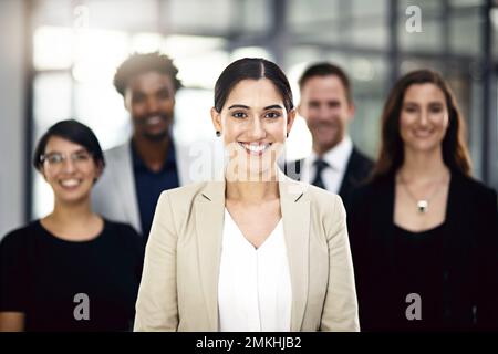 I miei team mi hanno fatto le spalle. Ritratto ritagliato di un gruppo di uomini d'affari in piedi in ufficio. Foto Stock