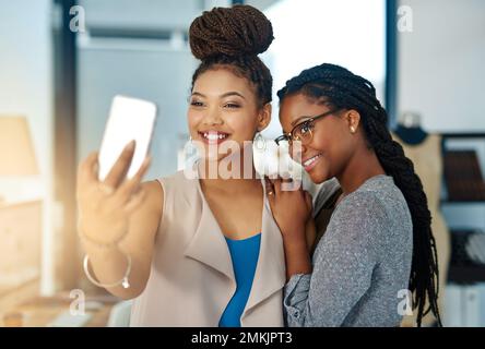 Theres sempre tempo per un selfie. due giovani stilisti di moda che prendono un selfie al lavoro. Foto Stock