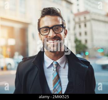 La vita cittadina mi fa sorridere. Ritratto di un giovane uomo d'affari felice in città. Foto Stock