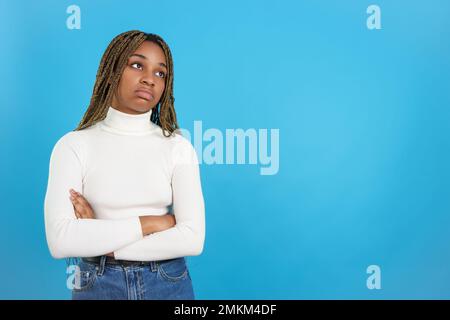 Donna africana annoiata in piedi con le braccia piegate Foto Stock