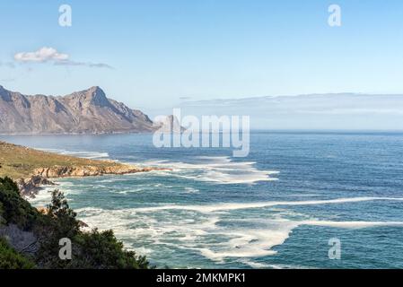 Vista da Clarence Drive vicino a Gordons Bay nella provincia di Western Cape. Rooiels è visibile attraverso la baia Foto Stock