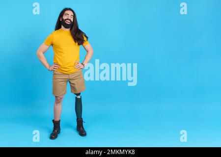 Uomo felice con protesi gamba sorridente mentre si posa Foto Stock