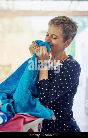 Adora l'odore della lavanderia fresca. una donna che odora un po' di lavanderia. Foto Stock