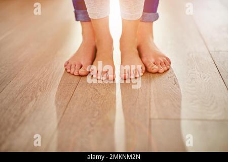 Seguendo le orme delle mamme. Colpo di primo piano di una madre e dei suoi piedi bambini insieme. Foto Stock