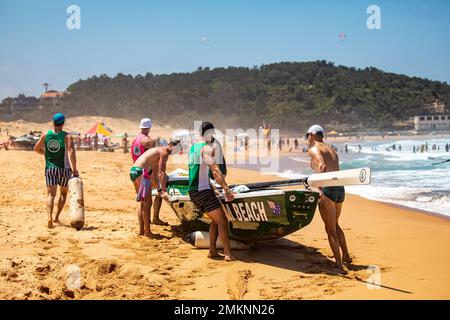 Sydney Northern Beaches Surfboat carnevale a North Narrabeen Beach, gli equipaggi di Surfboat rimuovono il Surfboat dalla spiaggia utilizzando i parafanghi per barche a rolling boat Foto Stock