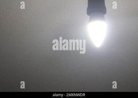 Lampadina nel soffitto bianco in cemento Foto Stock