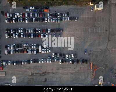 Vista aerea su un enorme parcheggio all'aperto con molte auto e veicoli a Genova, Italia Foto Stock