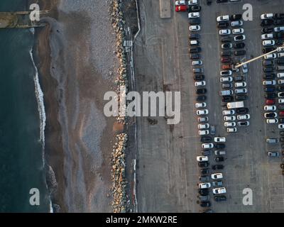 Vista aerea su un enorme parcheggio all'aperto con molte auto e veicoli a Genova, Italia Foto Stock