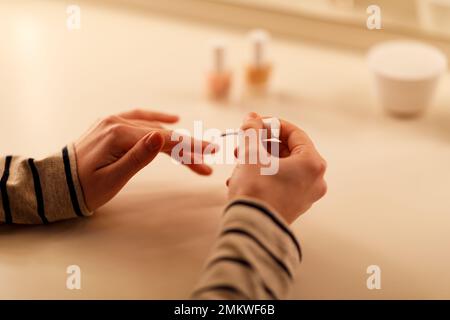 Ritagliata di donna che fa manicure a casa Foto Stock
