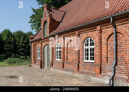 Facciata in mattoni rossi delle vecchie scuderie nel giardino del Castello di Rosenholm, Jutland, Danimarca Foto Stock