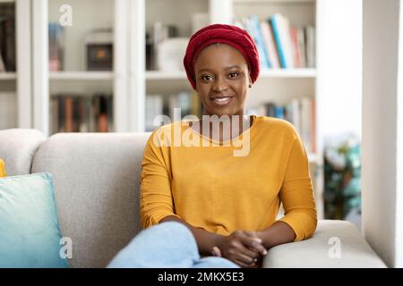 Giovane donna nera calma che si rilassa sul divano nel soggiorno Foto Stock
