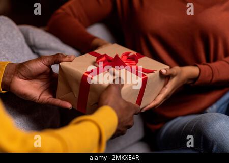Uomo e donna irriconoscibile in possesso di una confezione regalo, tagliato Foto Stock