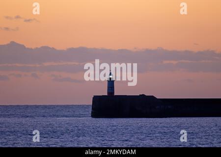 Faro di Newhaven in Sussex, al tramonto nel gennaio 2022. Foto Stock