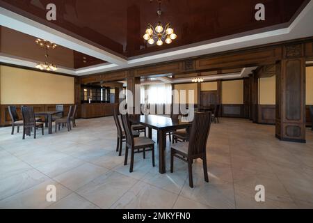 interni spaziosi di un grande e moderno ristorante vuoto con tavoli e sedie Foto Stock