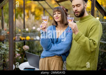 Coppia appendere insieme al vino in giardino Foto Stock