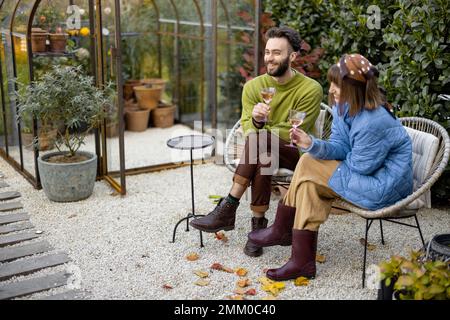 Le giovani coppie hanno una serata romantica con vino vicino al fuoco Foto Stock