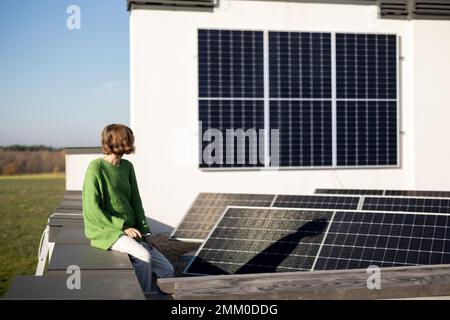Donna sul tetto della sua casa con una stazione solare Foto Stock