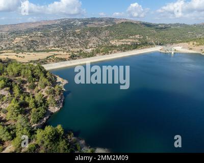 Vista aerea sul lago d'acqua dolce con diga per l'irrigazione e il bere nel centro collinare dell'isola secca e soleggiata di Cipro Foto Stock