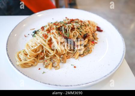 Pasta o pasta piccante o spaghetti piccanti, spaghettini all'aglio e peperoncino secco o spaghetti al peperoncino secco da servire Foto Stock