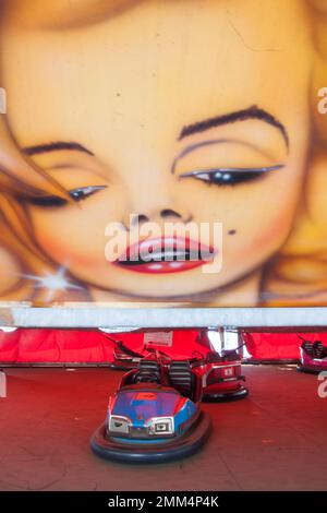 Massive Girls faccia guardando giù su una macchina dodgem in un campo da fiera Foto Stock