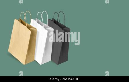 Sacchetti di carta per lo shopping su sfondo verde. Spazio di copia Foto Stock