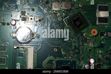 Scheda a circuito stampato verde di un vecchio notebook che assomiglia a una città fantascientosa Foto Stock