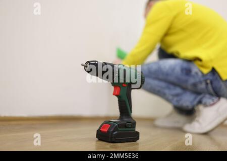 Primo piano del trapano in piedi sul pavimento, un manipolo professionale sullo sfondo. Foto Stock