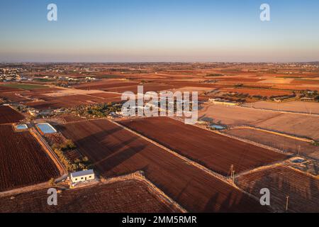 Vista dei campi con suolo rosso intorno al villaggio di Avgorou nel distretto di Famagosta, nella regione dell'isola di Cipro Foto Stock