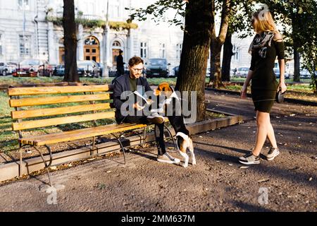 l'uomo con un'aquila saluta una giovane bionda nel parco Foto Stock