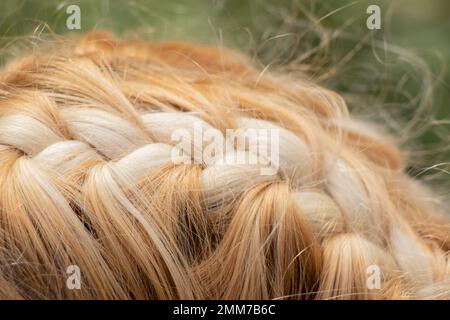 fettine intrecciate sulla testa di una giovane ragazza bionda closeup Foto Stock