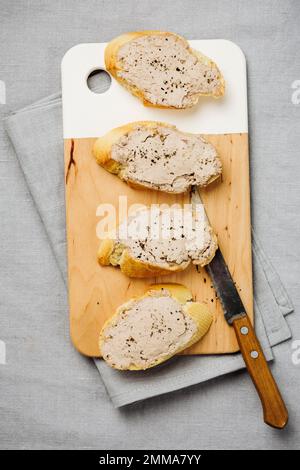 Baguette con pate di fegato su una tovaglia di lino. Foto Stock